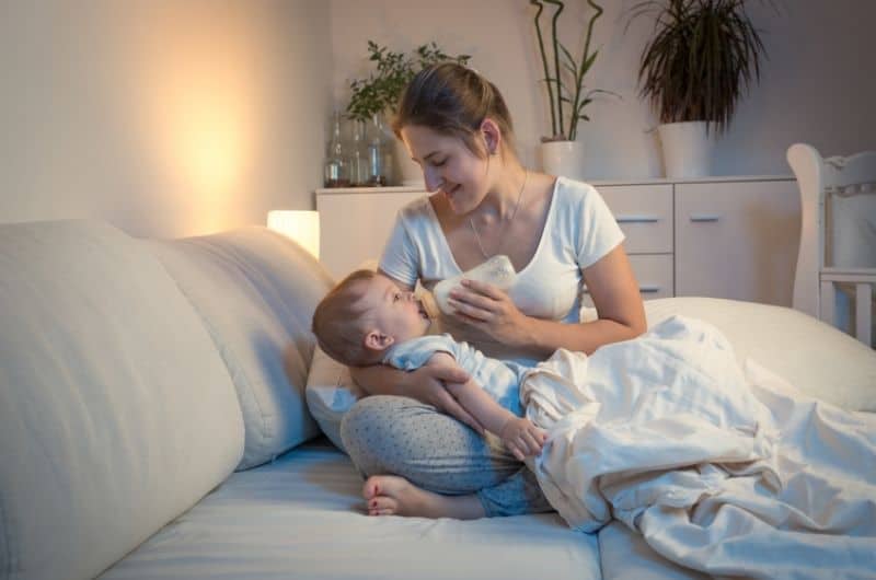 Mom bottle-feeding her baby in a safe way to prevent choking