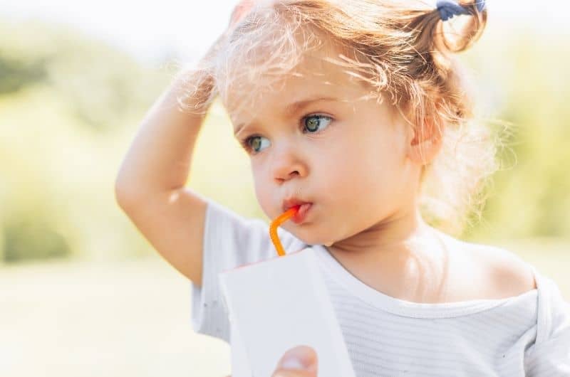 Toddler girl drinking from a straw to help with her excessive drooling.