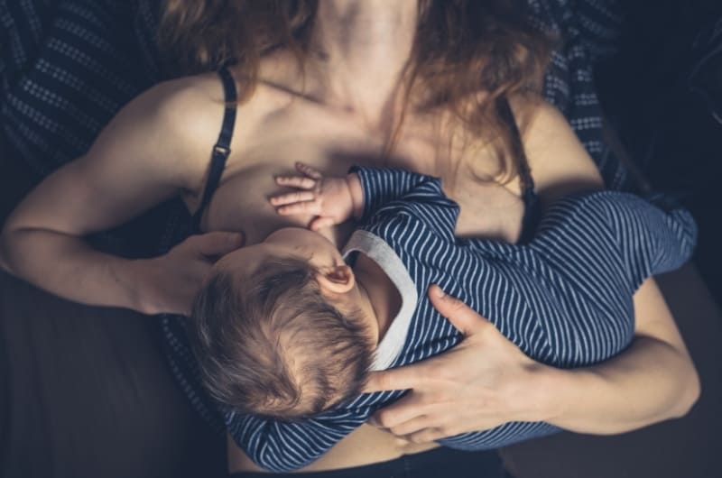 Mom breastfeeding her baby frequently referred to as cluster feeding.