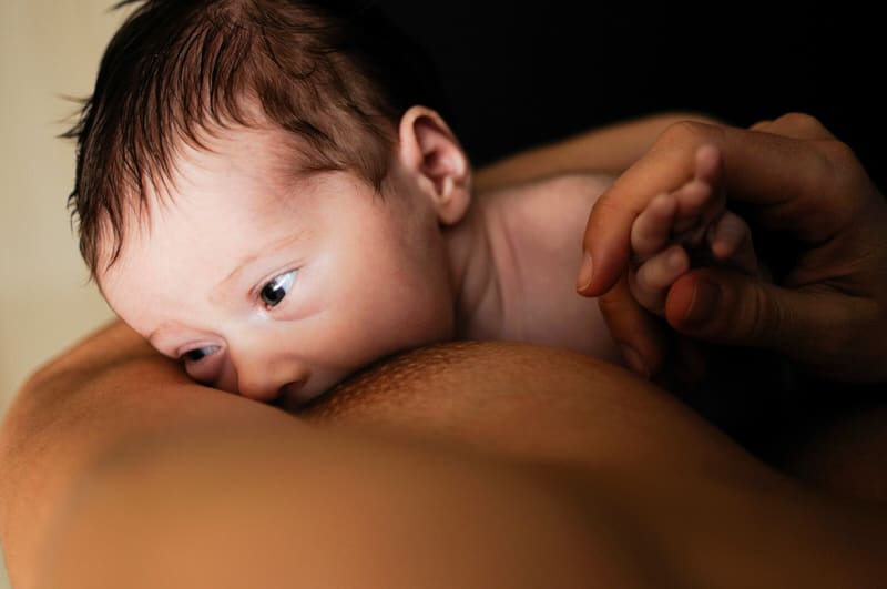 A newborn baby is breastfeeding. This is sometimes how newborn babies get jaundice, from mom's breastmilk.