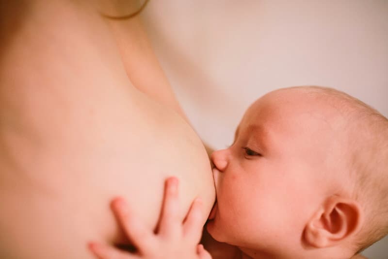A mom is breastfeeding her infant boy.