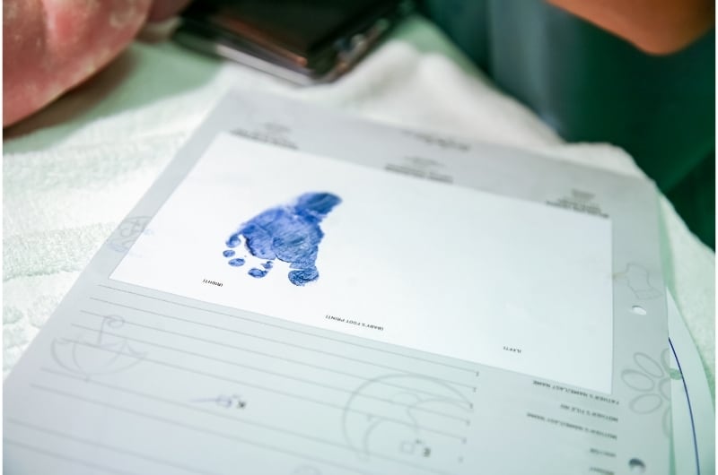 A document with a newborn baby's footprint taken in blue ink.