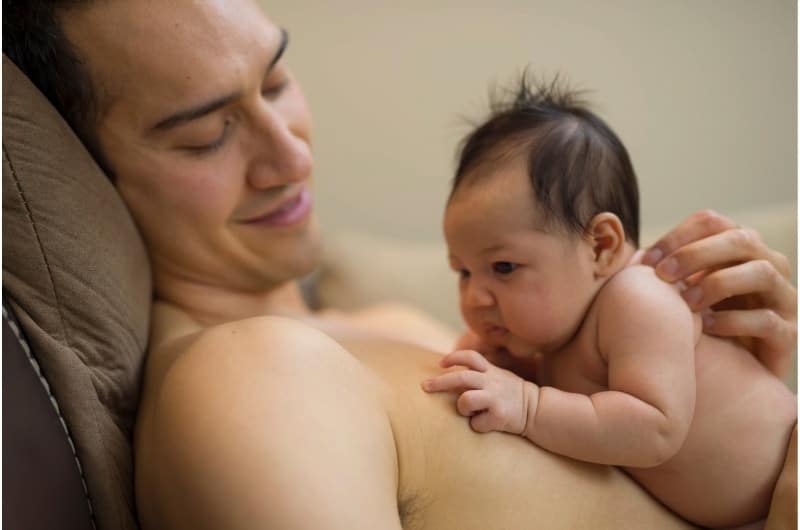 A newborn boy is getting skin-to-skin contact time with his dad.
