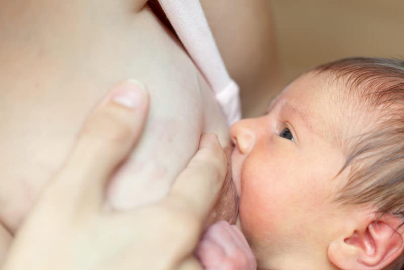 A mom is breastfeeding her newborn son. Her engorged breasts are causing her chest pain.
