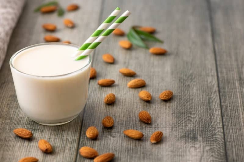 A cup of almond milk, a possible alternative to an infant or toddler who is having a negative reaction to drinking whole milk.