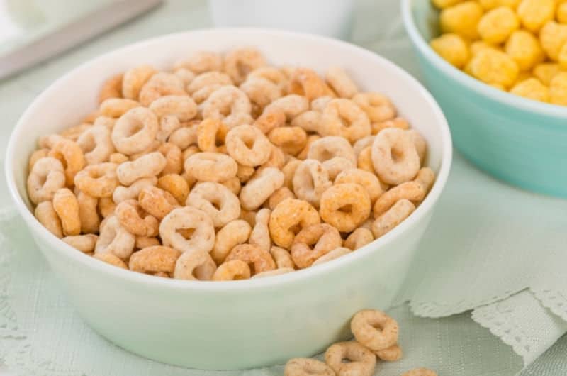 A bowl of honey nut cheerios on a kitchen table.