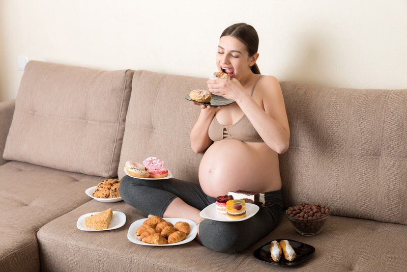 A pregnant woman who's in her 3rd trimester is enjoying some sweet foods that she has been craving.