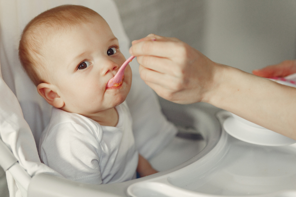 An infant boy is starting solids after self-weaning from breastfeeding.