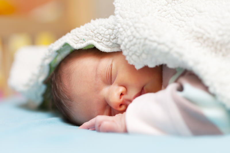 A newborn baby is deep asleep and isn't waking up to feed.