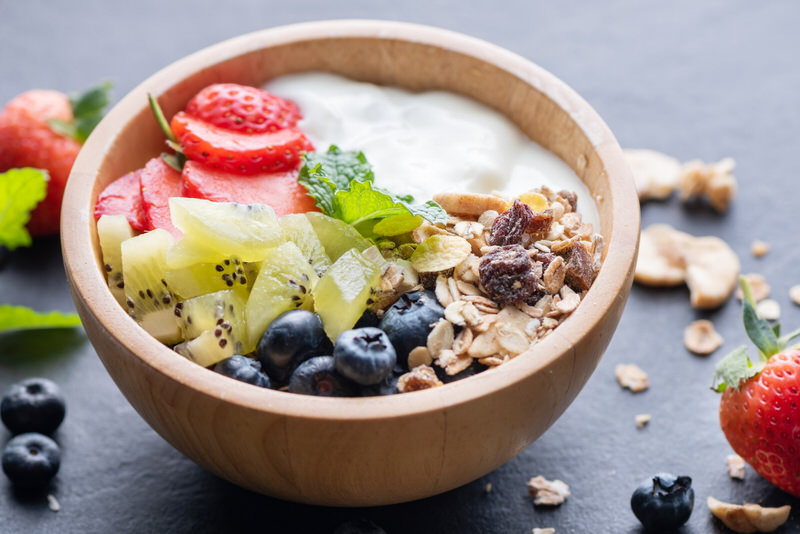 A bowl of oatmeal with lots of fruits and nuts on top to make it an enjoyable and healthy meal for pregnant women.