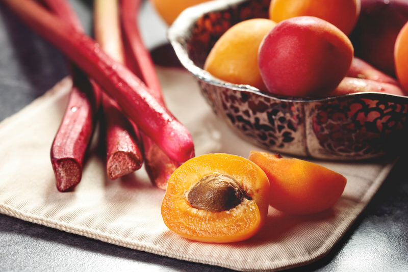 A plate with rhubarb and peaches is ready for eating.