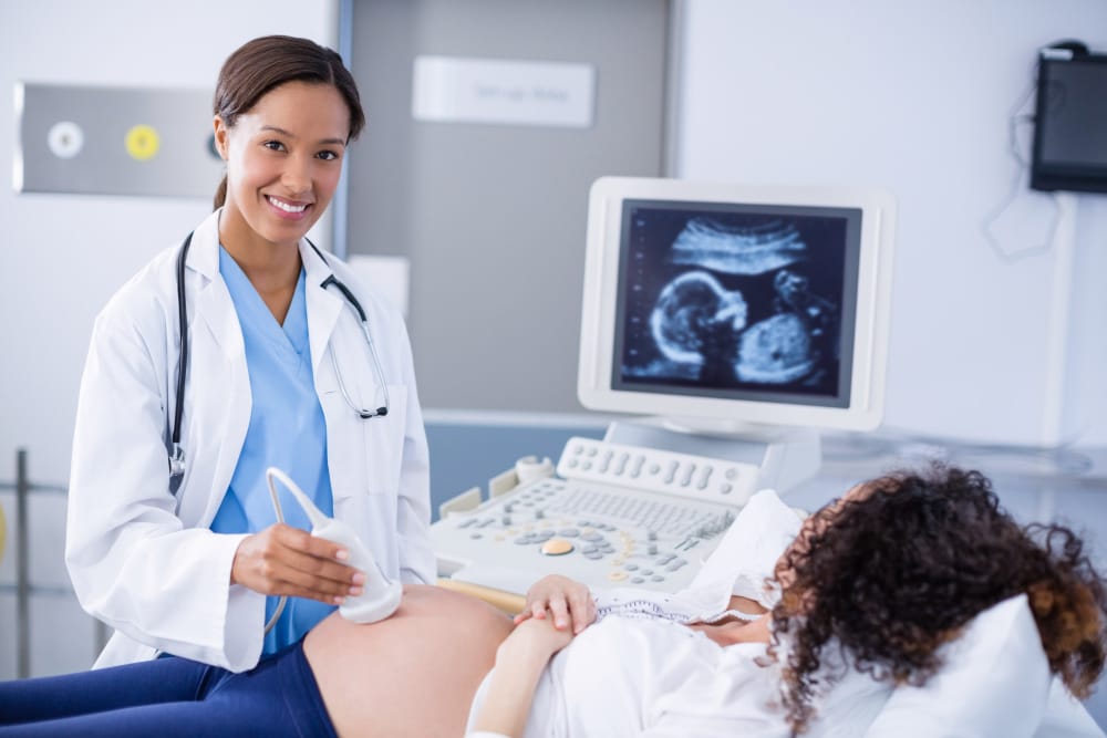 An OB-GYN is doing an ultrasound on her pregnant patient to check the gender of the baby
