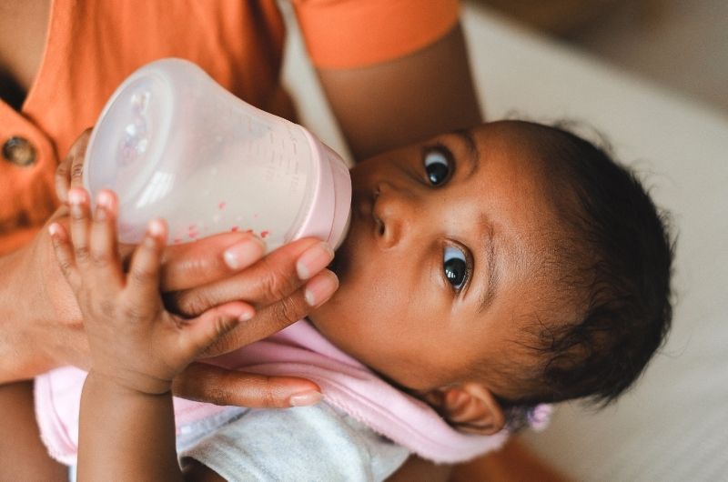 A mom is bottle-feeding her infant baby