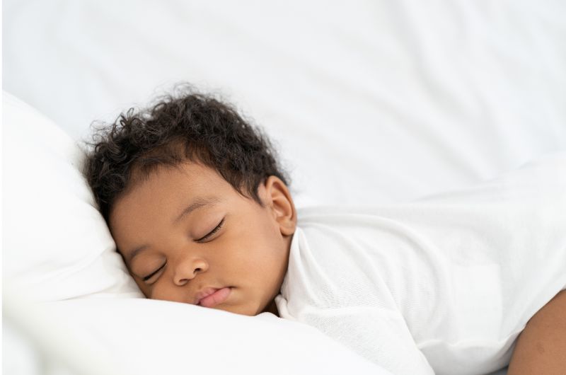 An infant baby boy is sleeping with his butt in the air