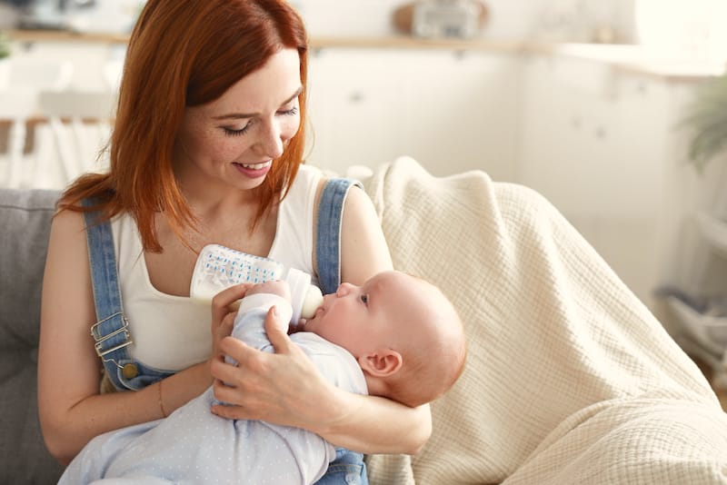 A mom is transitioning her baby from breastfeeding to bottle feeding