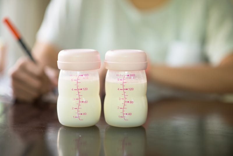 A dad is preparing breastmilk to be used to feed his baby during an upcoming trip