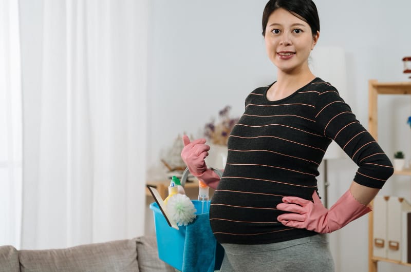 A pregnant woman is about to clean her house with pregnancy safe household cleaners