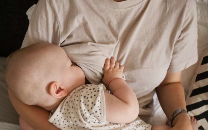 Young mother trying to breastfeed her baby but feeling an aversion towards breastfeeding.