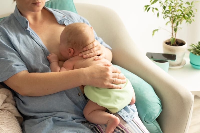 A mom is breastfeeding her newborn baby, which burns a lot of calories for mom.