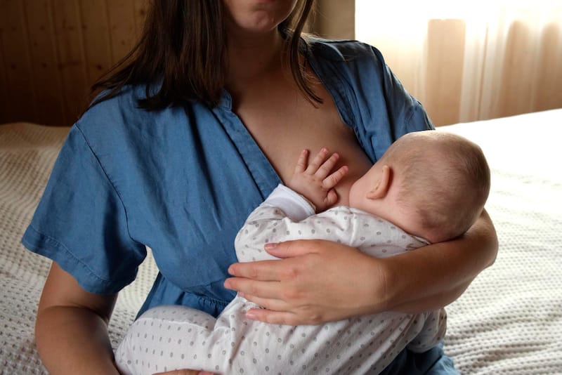 A mom is breastfeeding her infant son