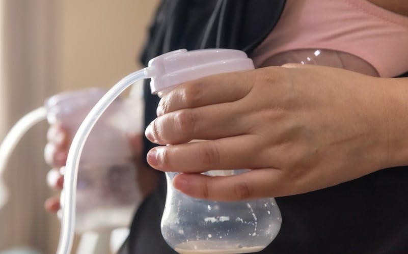 A woman is using a breast pumping machine at work.