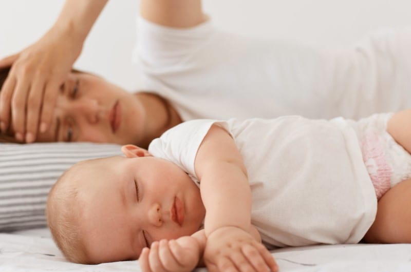 A tired and exhausted mom can't seem to get good sleep due to taking care of her newborn.