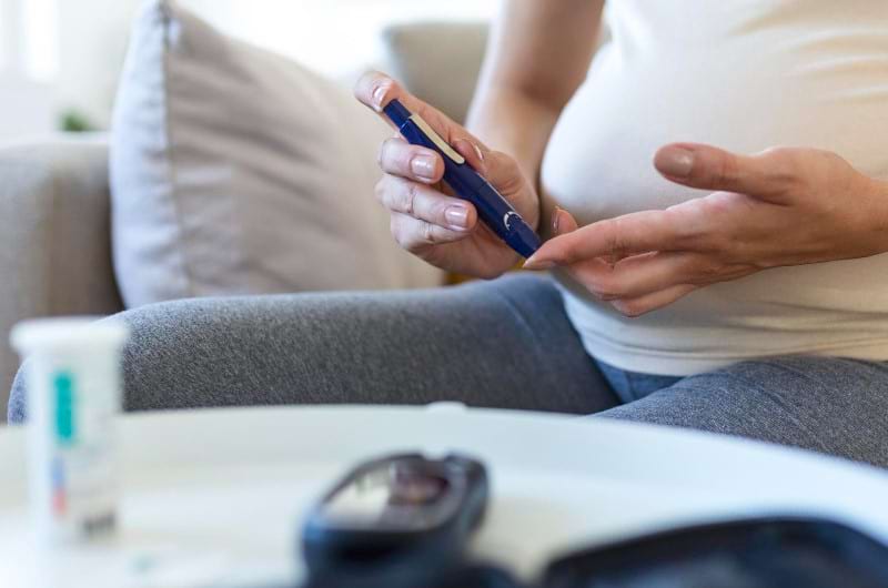 A pregnant woman checks her blood sugar level.