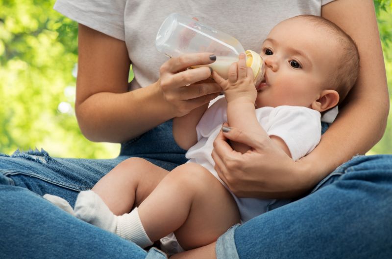 A mom is bottle-feeding breastmilk to her newborn baby